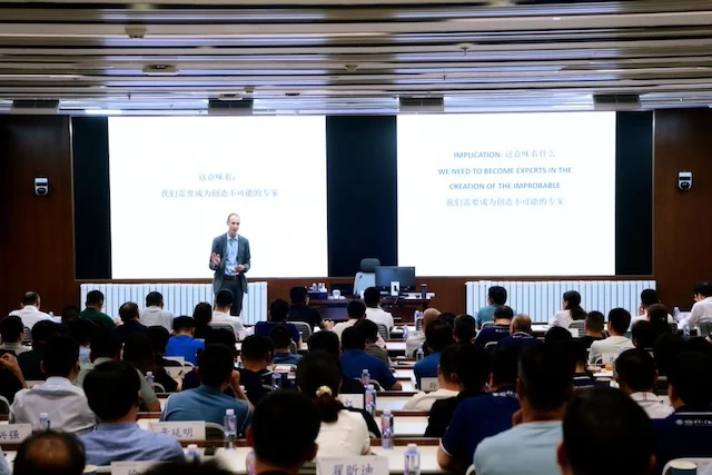 Chuck Eesley delivering a keynote on entrepreneurship education to a packed bilingual lecture hall